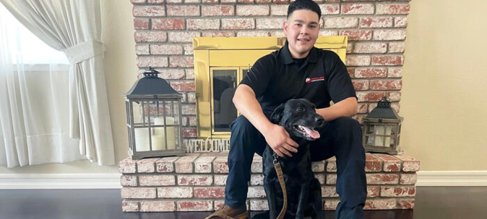 Black dog sitting with his owner